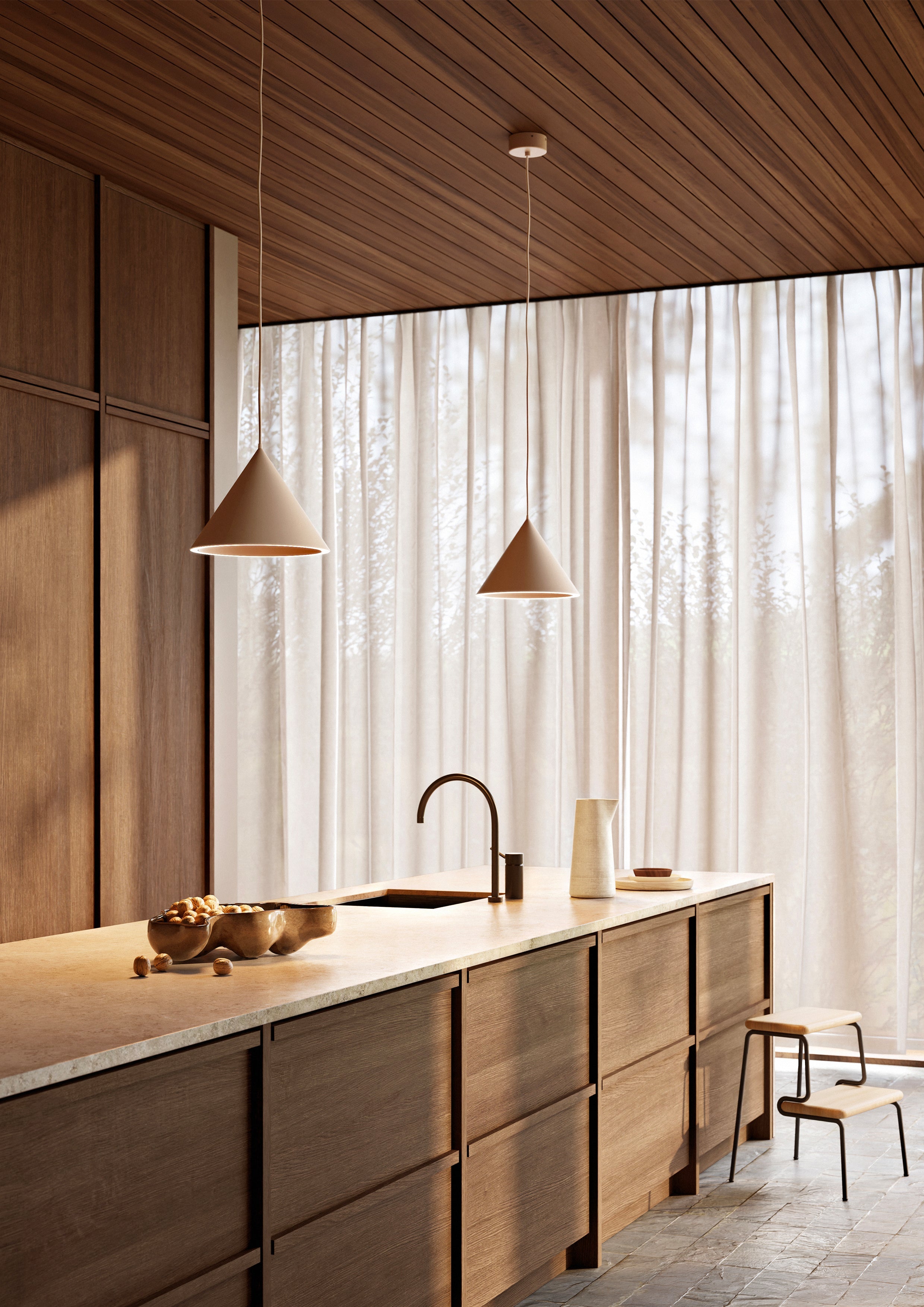 Two beige pendant lights hanging above kitchen counter with off-white countertop and dark wood cabinets.