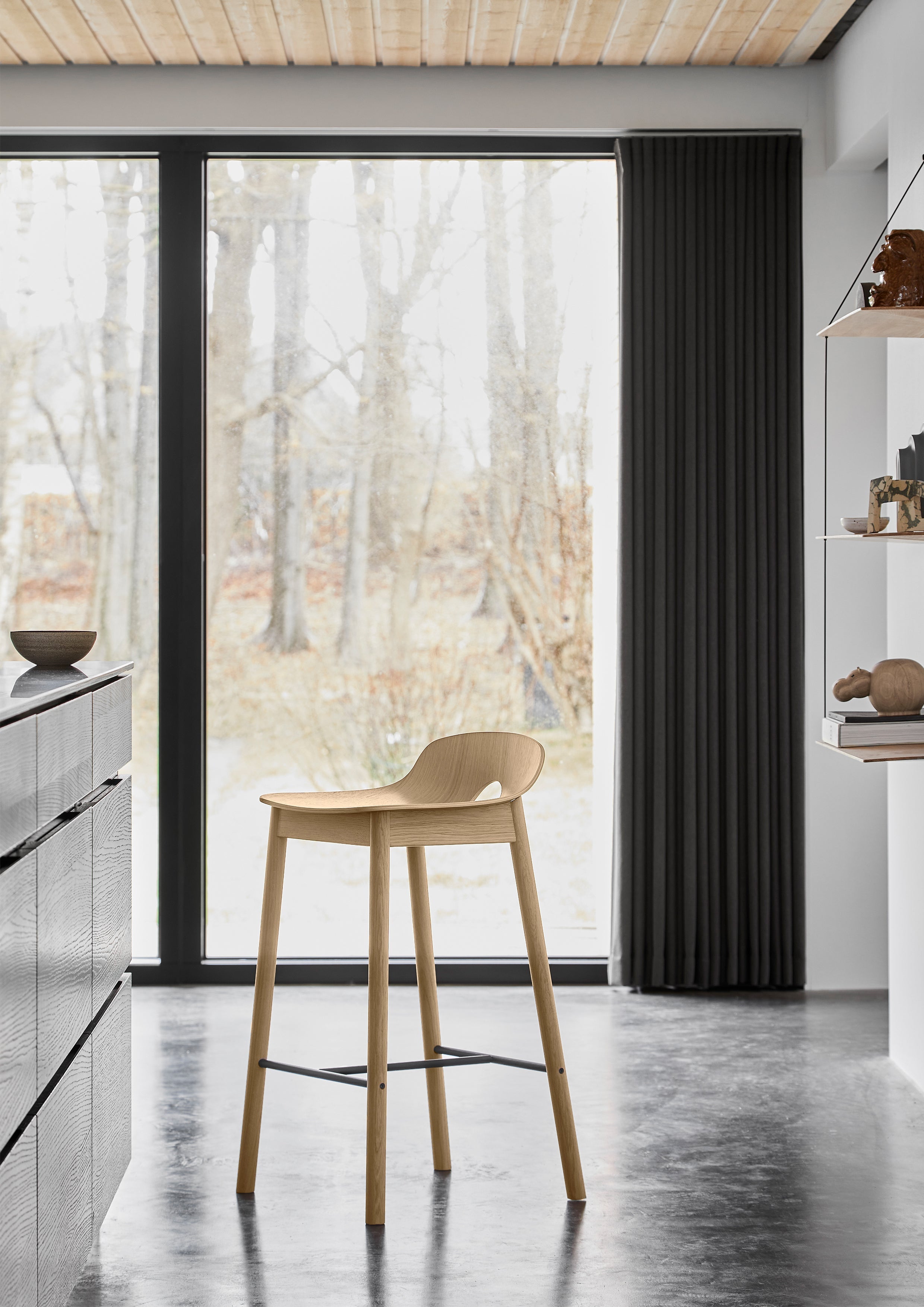 Bar stool in white pigmented oak in kitchen with natural light from large windows.