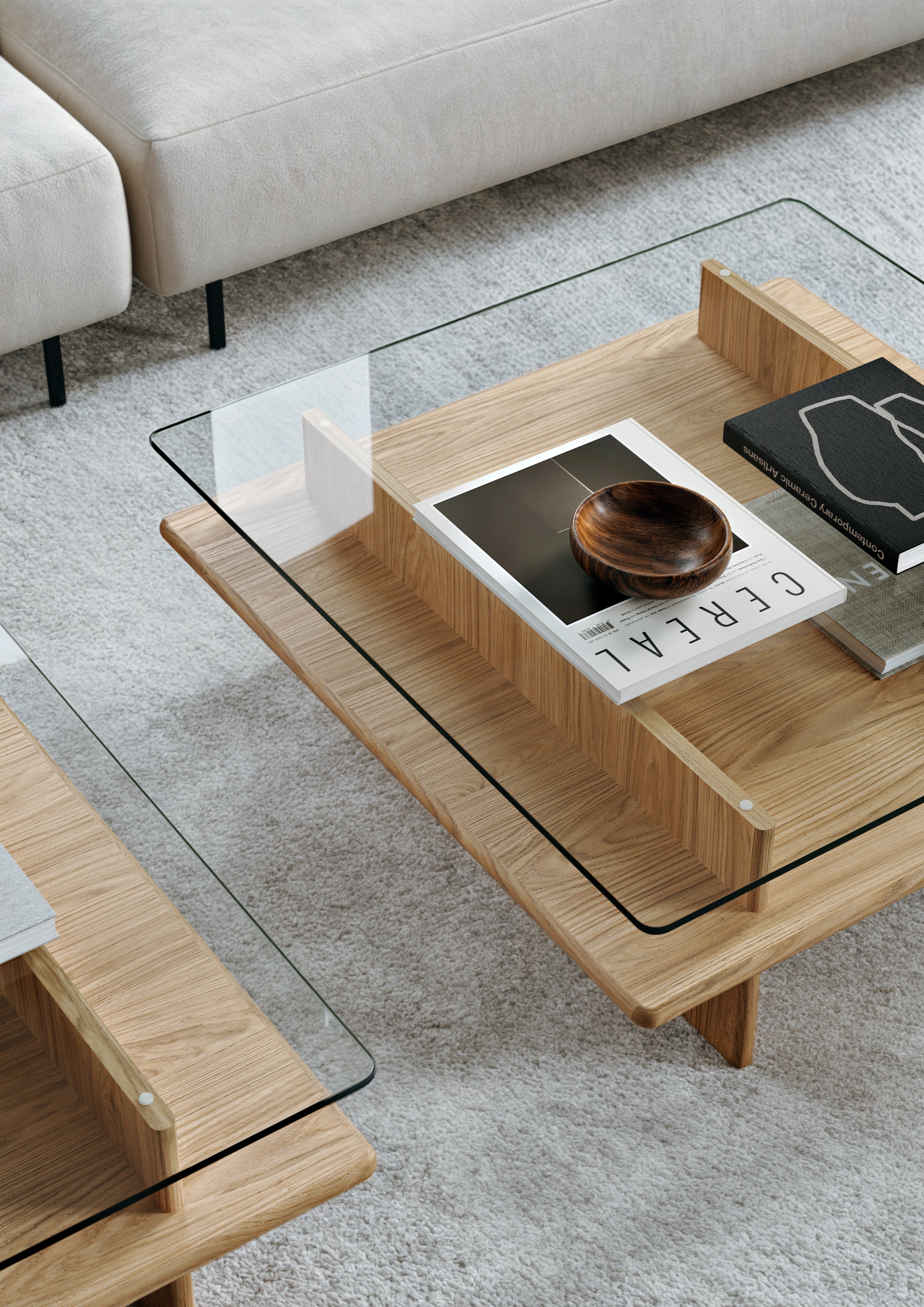 Off-white sofa with a coffee table in white-pigmented oak with glass top in a Scandinavian living room.