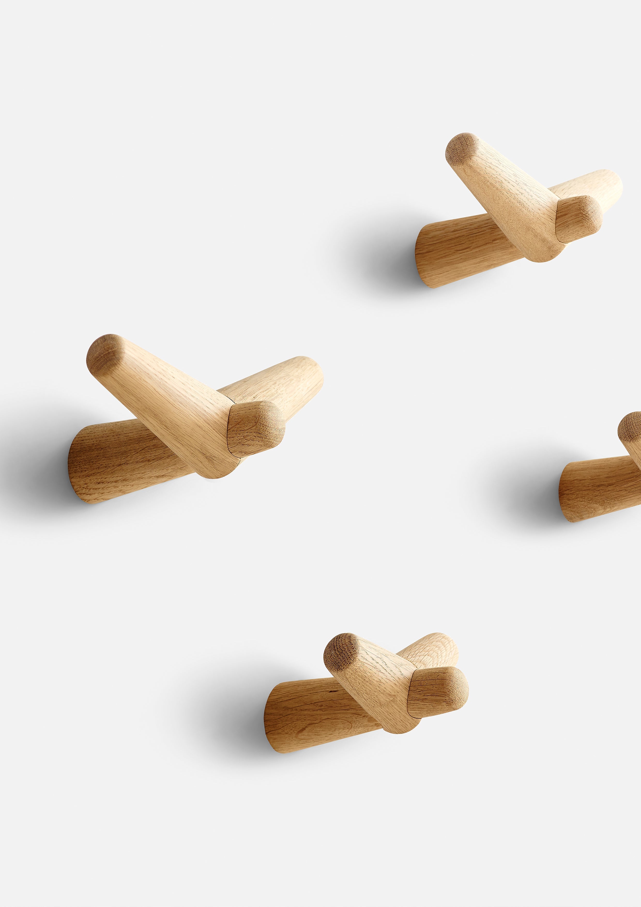 Minimalist wall hooks in white pigmented oak.
