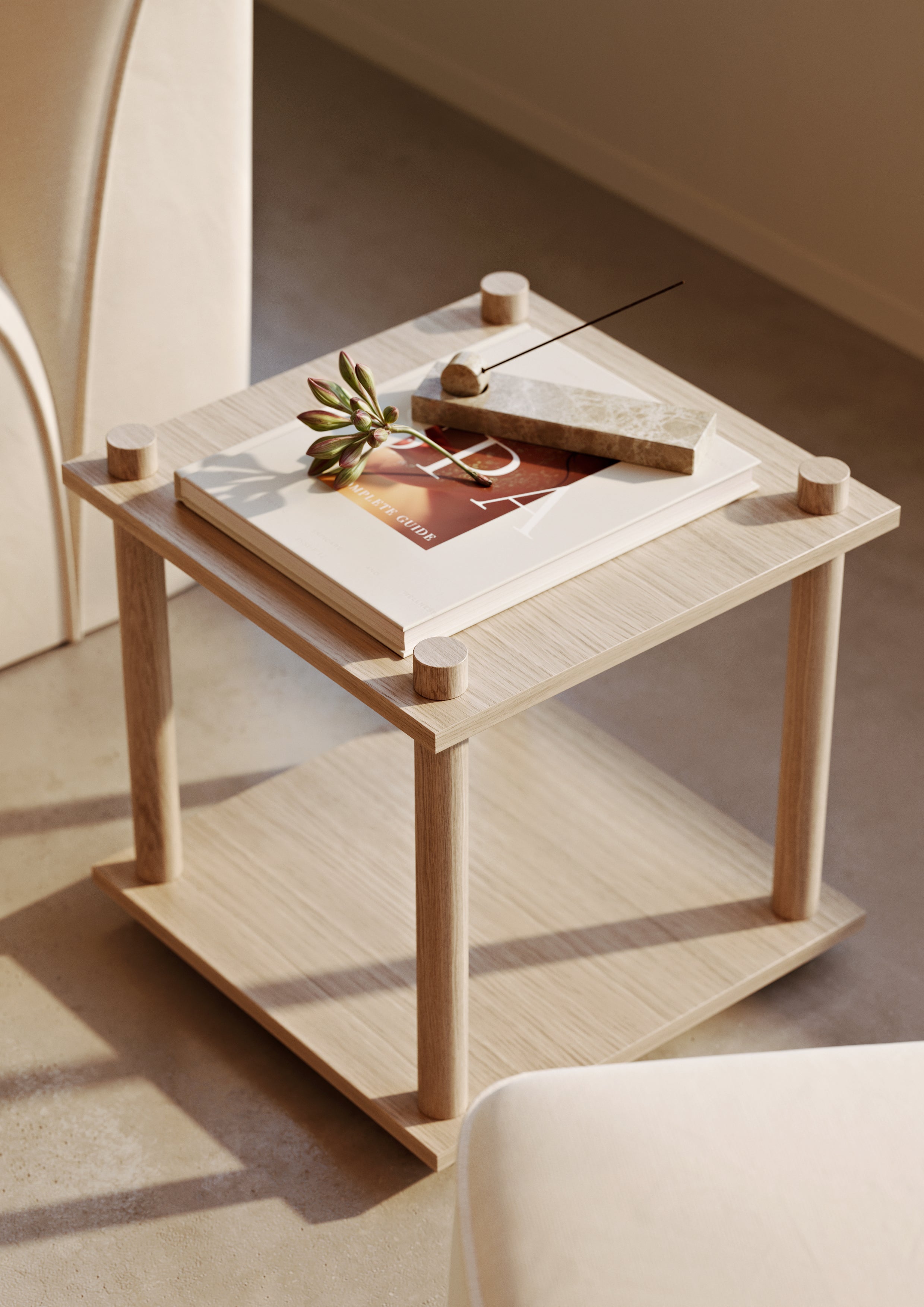 Small cube made from flexible oak shelving system with marble incense holder on top.