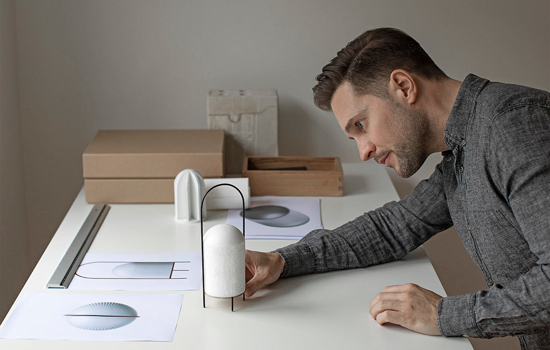 Designer Andreas Kowalewski looking at lamp prototype.