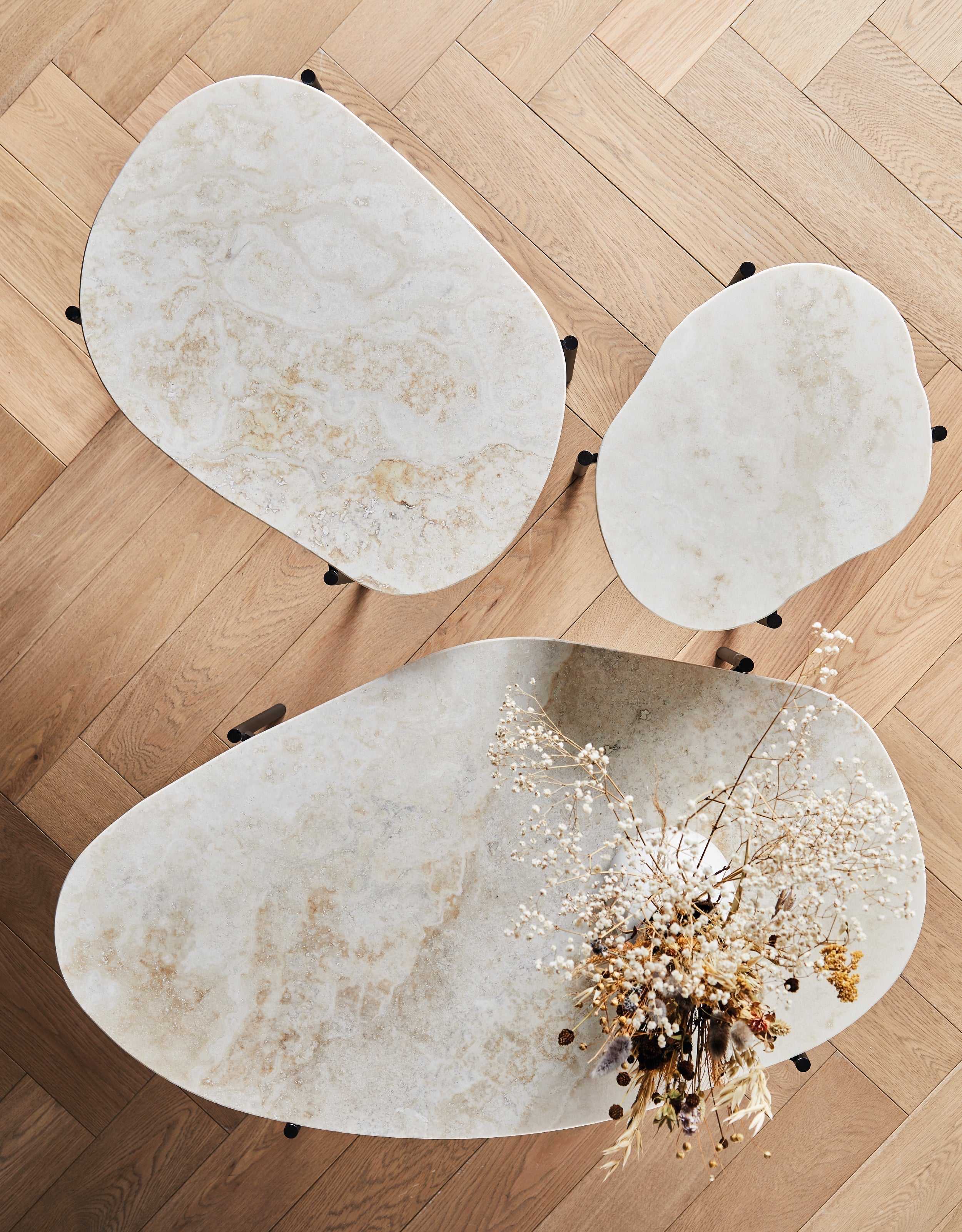 Three ivory travertine coffee tables viewed from above.